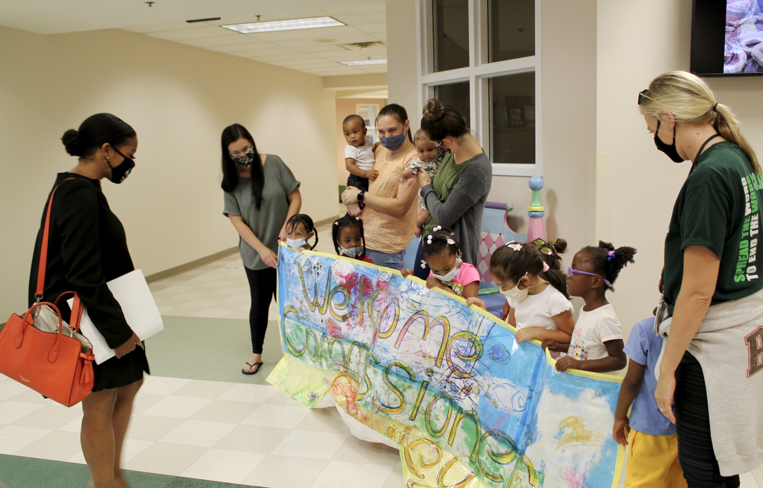 Children holding welcome banner for Commissioner Crawley