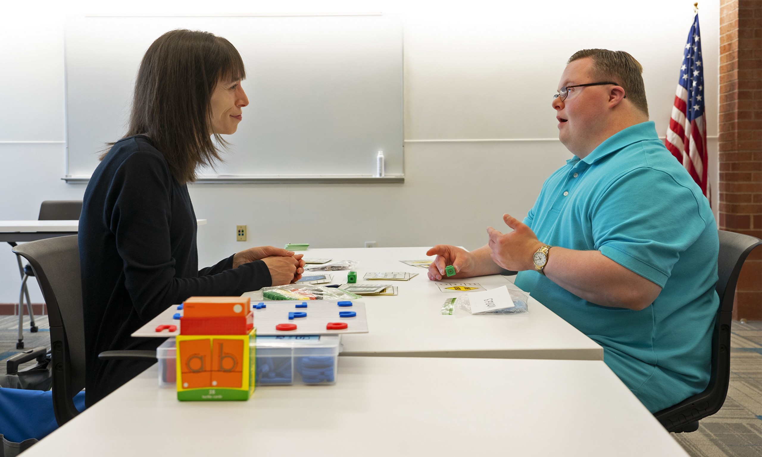 Reading tutor Carla Harper sits across from Ethan Boerner, who is sounding out words.