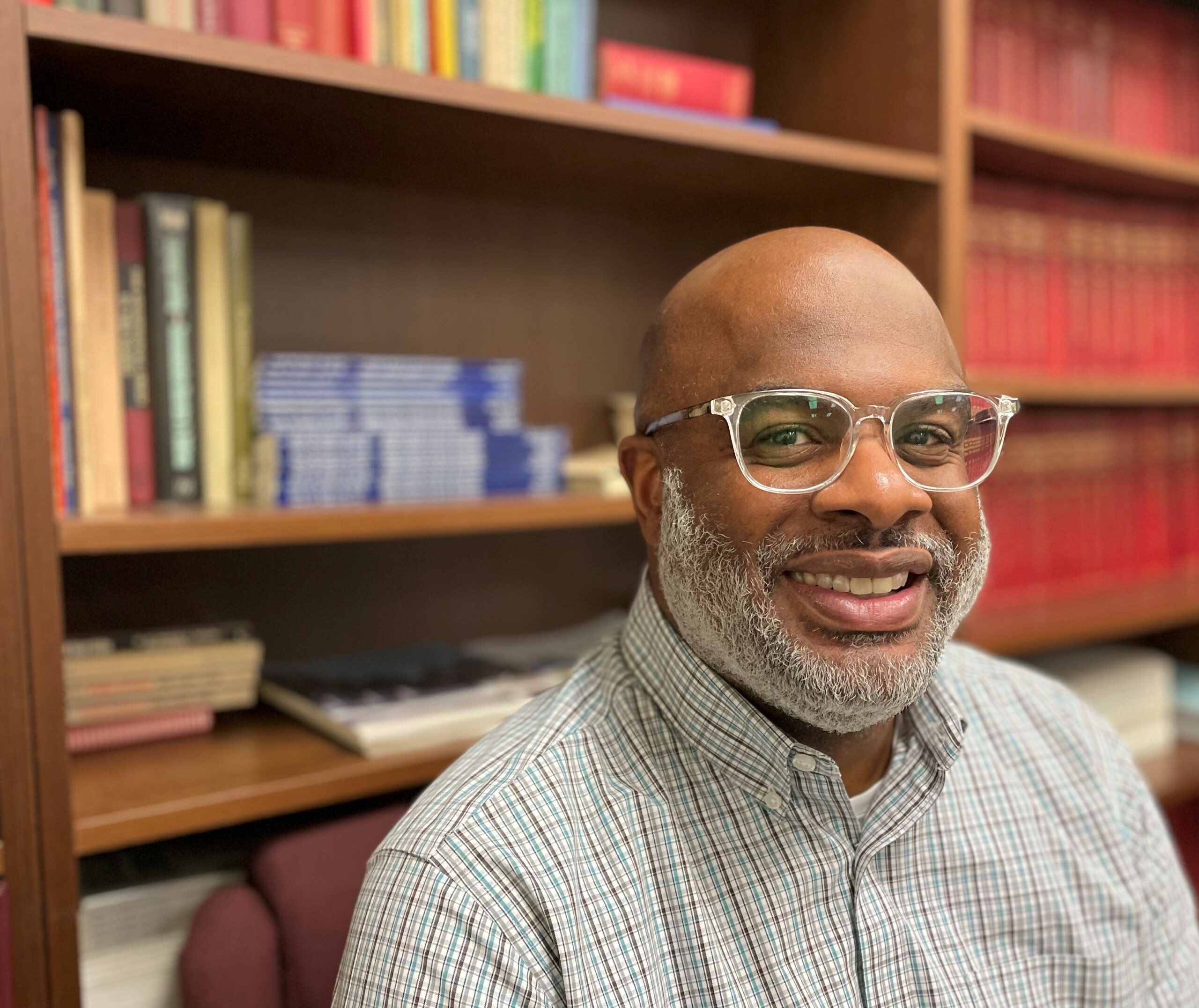 Smiling man in front of bookcase