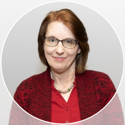 Photo portrait of smiling woman with glasses, red blouse and sweater