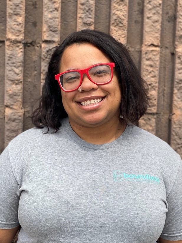 Smiling woman wearing red glasses and gray shirt